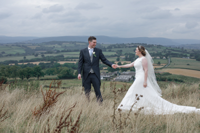 Hereford%20wedding%20photographer%20-%20a%20couple%20walk%20together%20with%20rolling%20welsh%20hillside%20sits%20in%20the%20background